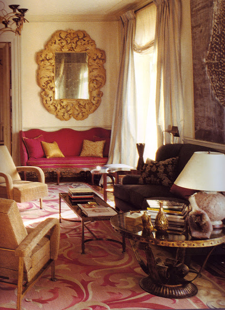 Formal living room with two rope armchairs, a pink Louis XIV armchair under a large antique mirror, a brown sofa in front of a small coffee table with a large glass round table on the side