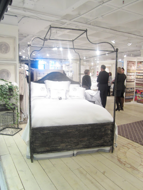 Large bed with metal canopy frame by Corsican at the The center room at Christian Mosso Associates showroom