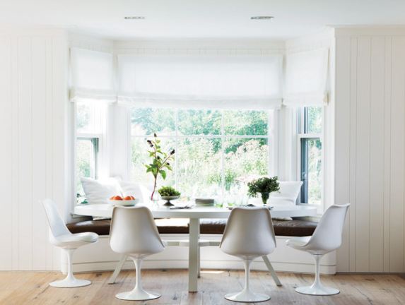 White breakfast nook with saarninen chairs and banquette leather window seating 