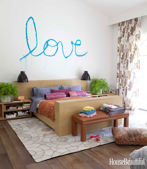 Todd Nickey and Amy Kehoe of Nickey Kehoe's bedroom in their Malibu home featured in House Beautiful with "love" spray painted on the wall in cursive