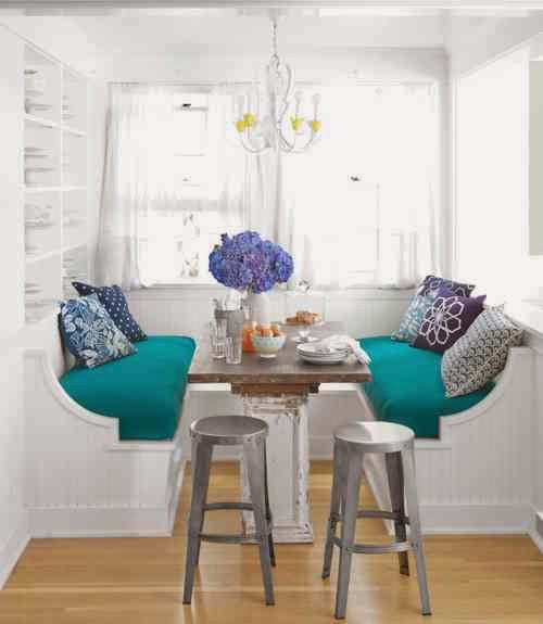 Breakfast nook with built in benches, a white chandelier and metal stools