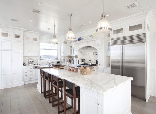 kitchen with island with marble counter top and white cabinets, bar seats, wood floors and three pendant lights