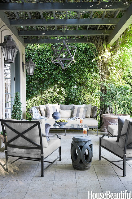 Neutral outdoor patio by Mary McDonald modern lighting grey sofa and armchairs Chinese garden stool