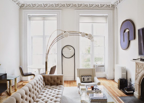 Living room with grey tufted sofa and decorative molding