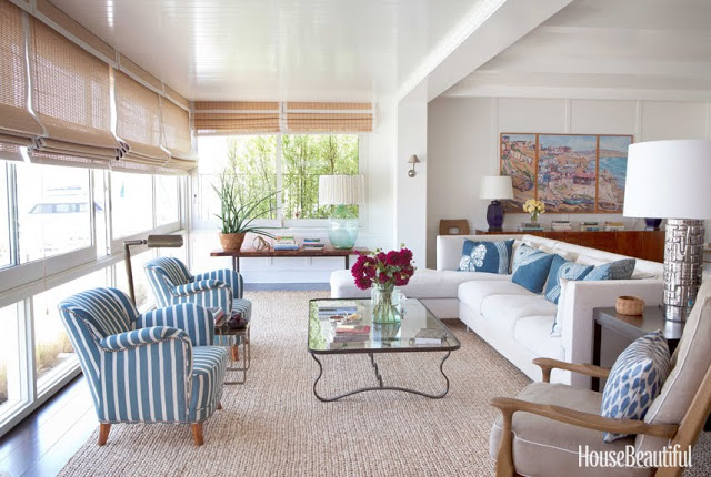 airy living room with white sofas, blue and white striped chairs and a glass table by Peter Dunham