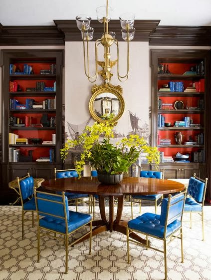 Dining room with built in shelves and vintage chairs with blue upholstery 