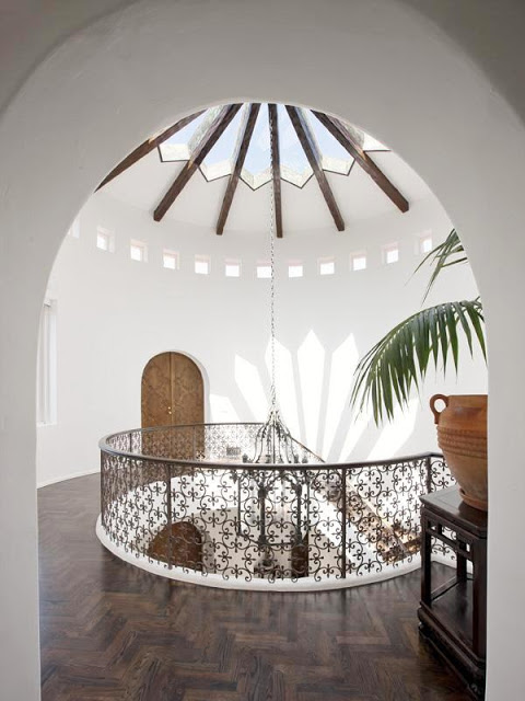 View from the second floor landing of the glass cathedral ceiling, Moorish ironwork railing and herringbone wood floors