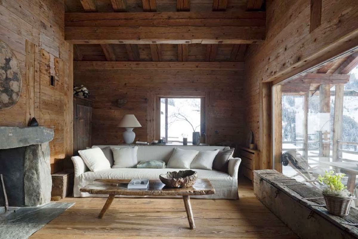 Fully wood paneled mountain home living room with stone slab fireplace and window seat