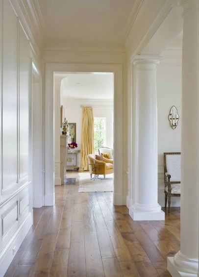 hallway in a san francisco mansion with wide plank wood floors and greek columns