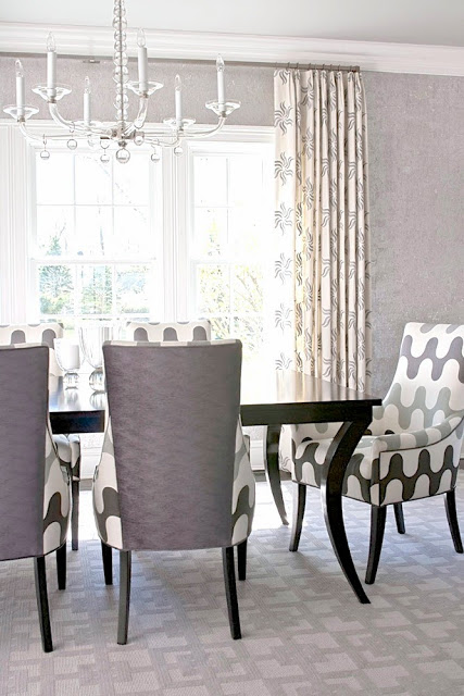 Grey dining room with graphic print upholstered chairs and carpeting
