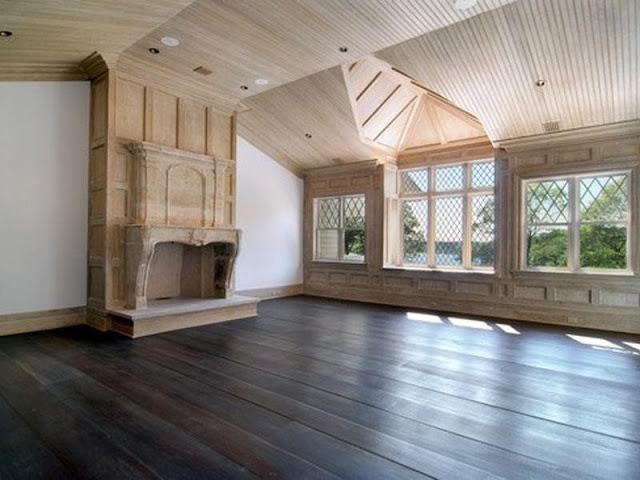 Unstaged bedroom Hamptons wood paneling windows fireplace