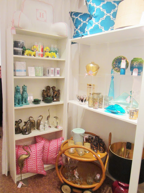 COCOCOZY Pillows in pink and peacock blue on a white shelf surrounded by other vintage finds