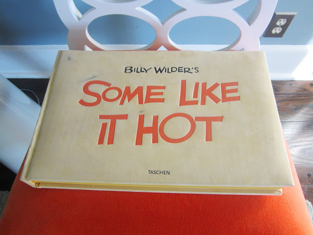 Bill Wilder's "Some Like it Hot" book from Taschen on a chair with a bright orange cushion