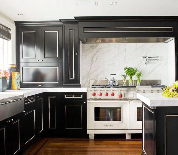 kitchen with black cabinets with white trim, wolf range stove and oven, and marble slab backsplash