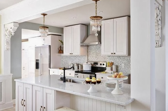 Bright, white kitchen after makeover with stainless appliances and mosaic tile backsplash