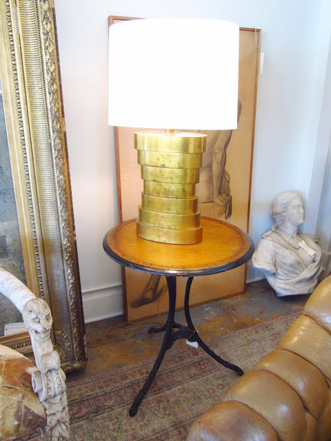 Table lamp with brass base on a round wooden side table