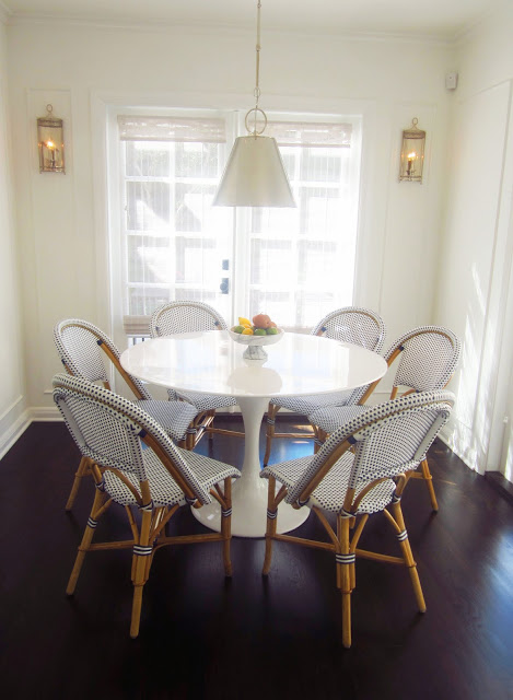 breakfast nook with white saarinen tulip table, blue and white french cafe chairs, silver pendant light, and dark wood floors
