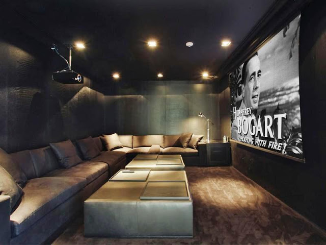 Home theater with projector screen, long sectional sofa and an equally long leather ottoman