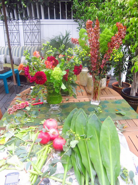 wooden patio table covered in different kinds of flowers and leaves