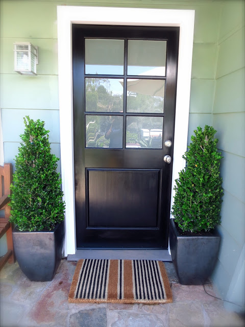 black front door frosted glass stripe striped doormat mat boxwood topiary plants decor design
