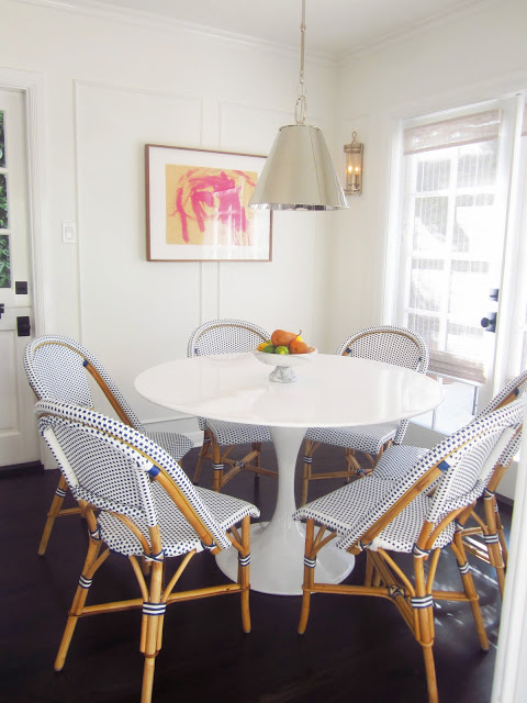 breakfast nook with saarinen tulip table, blue and white french cafe chairs, silver pendant light, and dark wood floors