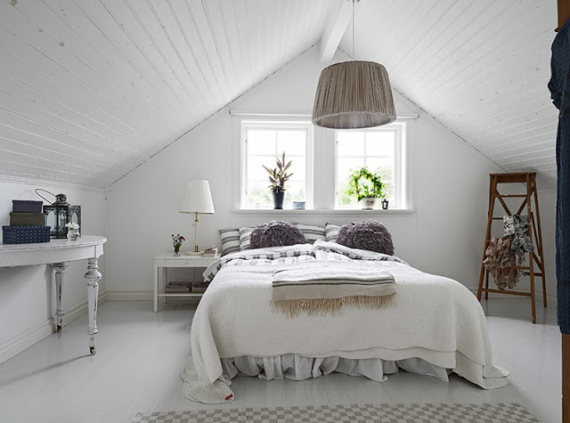 White mater bedroom in a Swedish cottage pitch ceiling painted wood floor pendant light