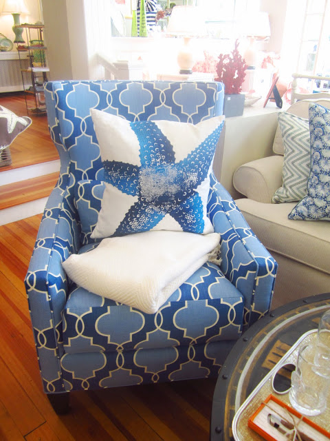 dark and light blue patterned arm chair with a white pillow with a blue starfish printed on it