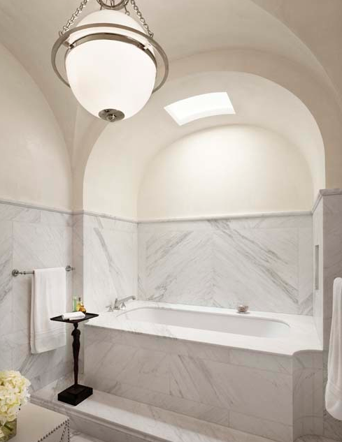 Marble bathroom with high curved ceiling by Michael Imber