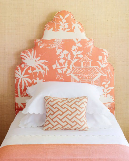 Twin bed with high coral colored upholstered headboard with a Chinoisserie print