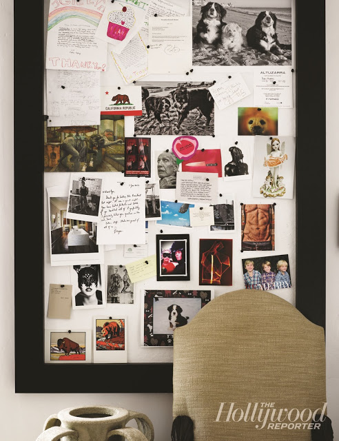 pin board with black frame holding photos and notes on a white wall