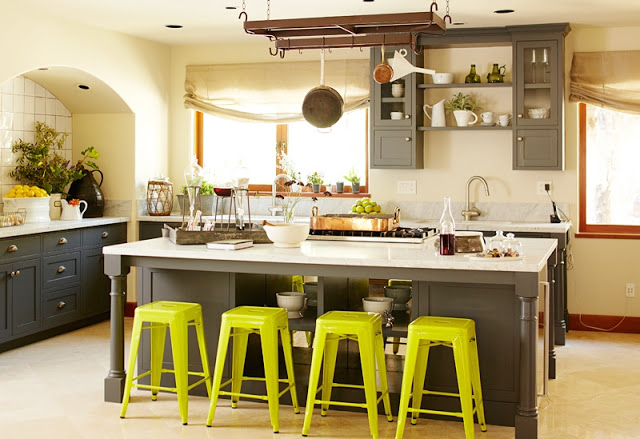 kitchen with gray cabinets, island with marble counter top, chartreuse stools and hanging pot rack