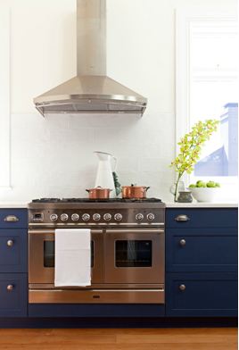 arent pyk's navy and white kitchen counters with stainless steel hood and recycled reclaimed wood floors