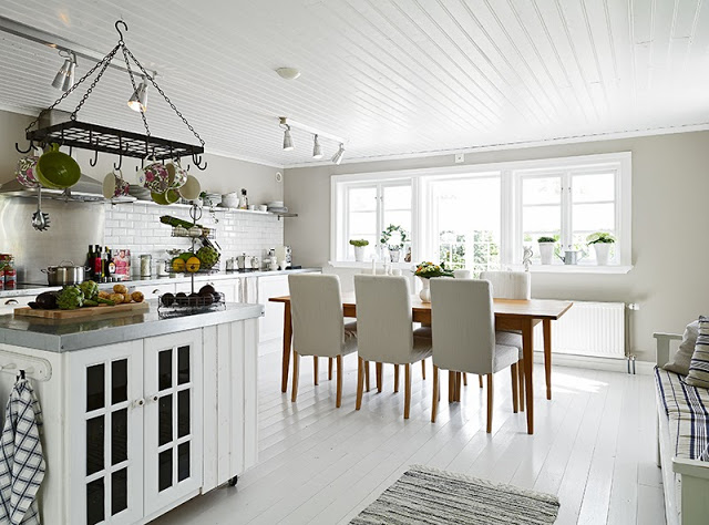 White kitchen swedish cottage wood table high back chairs painted wood floor white subway tile backsplash