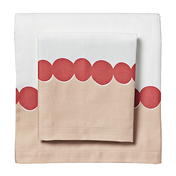 Bed sheets with a light brown bottom and white top separated at the half way point by a row of red dots