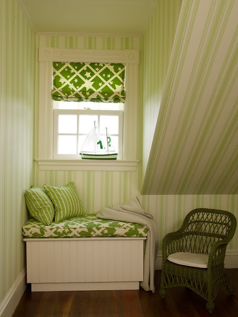 short window seat with green and white cushion, striped accent pillows and a slanted ceiling with green and white striped wall paper
