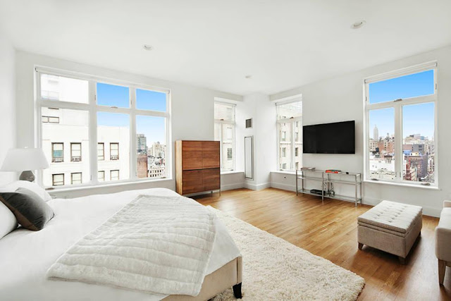 Modern bedroom in a NYC penthouse with wood floor, shag rug and views of the city