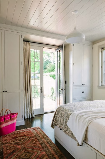 White bedroom with wood floor and French doors