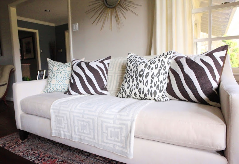 Living room with COCOCOZY Logo Throw in grey on a grey sofa with zebra print and leopard print pillows 