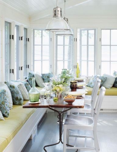 Eat in Kitchen with banquette seating with lime green cushions, a long wood table, metal chairs, pendant lights, paitned wood floor, and white casement windows