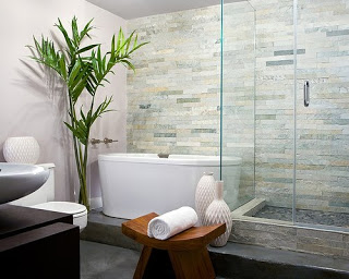 Modern spa like bathroom with glass shower, wood stool, tile wall and white stand alone tub
