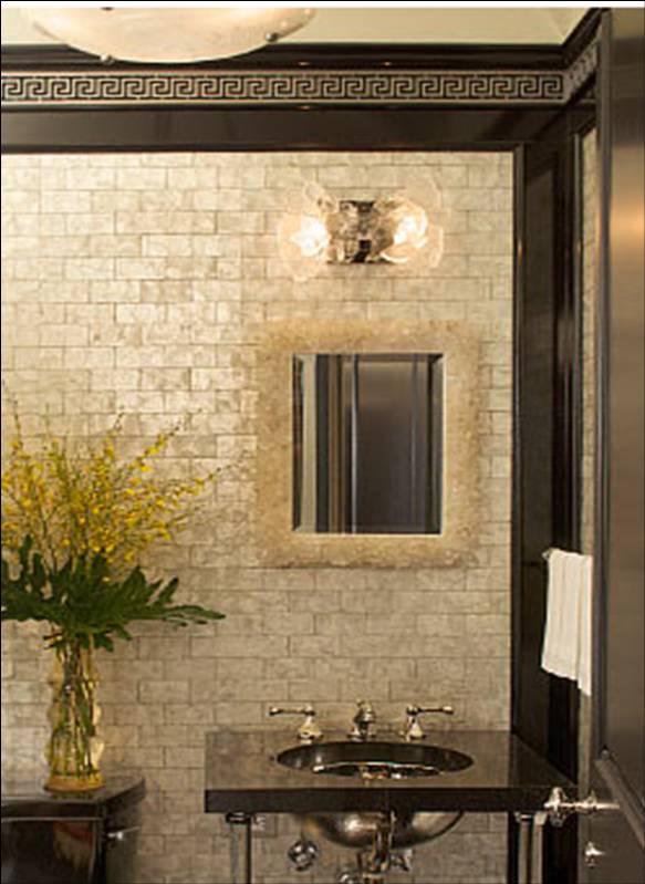 Powder room by Peter Pennoyer with marble tile walls, stand alone sink and black and gold tiled border