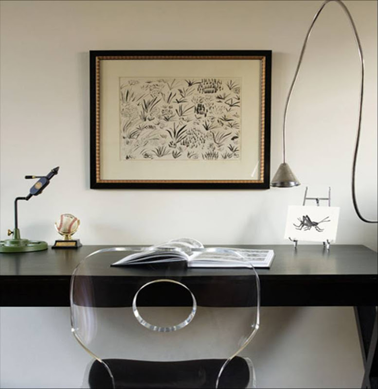 Black and white home office with a lucite desk chair with a cut out in the back and a wire lamp in front of a dark wood desk