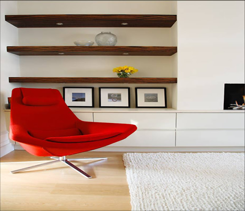 Modern living room with famous red armchair, floating natural wood shelf, sleek white drawers, light wood floor and a modern fireplace