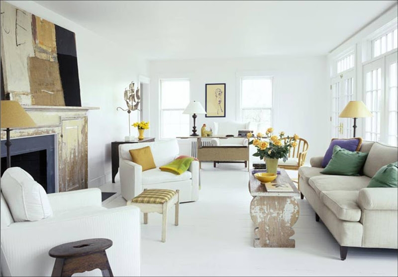 White living room with yellow lampshade, accent pillows and upholstered ottoman