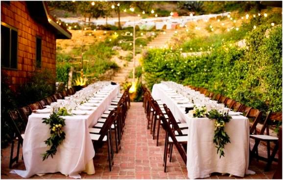 Outdoor wedding reception with Garlands made of California bay leaves, persimmons, raspberry branches and figs by Lily Lodge