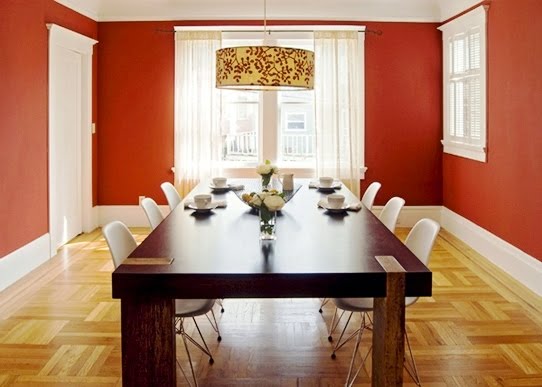Red dining room with long modern wood table, hand painted drum chandelier and plastic Eames chairs by Niche Interiors