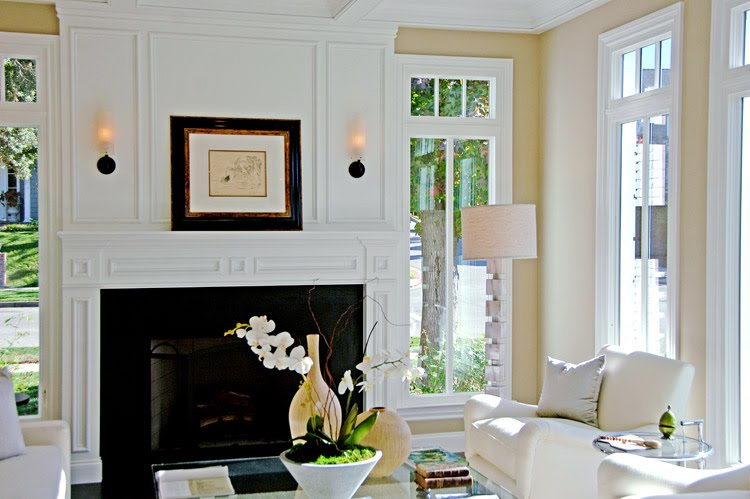 Close up of the fireplace's decorative molding and paneling in a living room by Meridith Baer