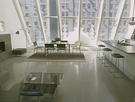 Open kitchen and dining room in New York City with slanted floor to ceiling windows