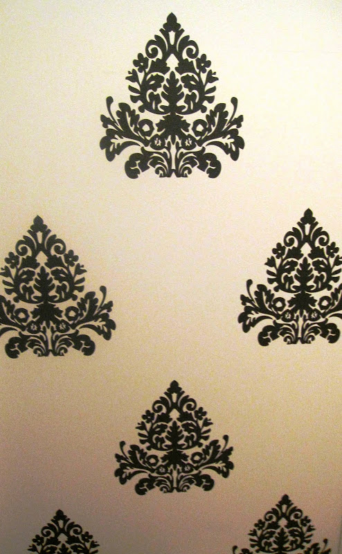 Close up of dark grey medallion brocade wall decals in the entryway of a nursery in a NYC loft