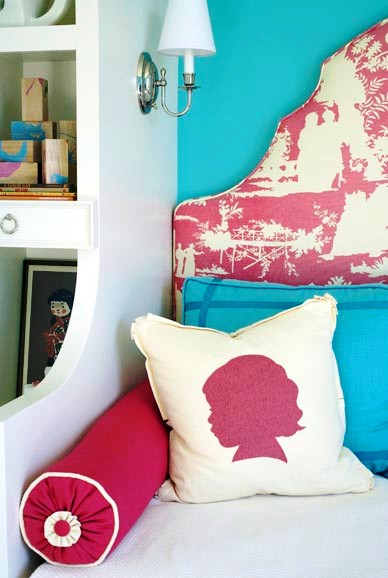 Bedroom with silhouette printed throw pillows match that match the pink and white toile upholstered headboard and turquoise pillows match the wall